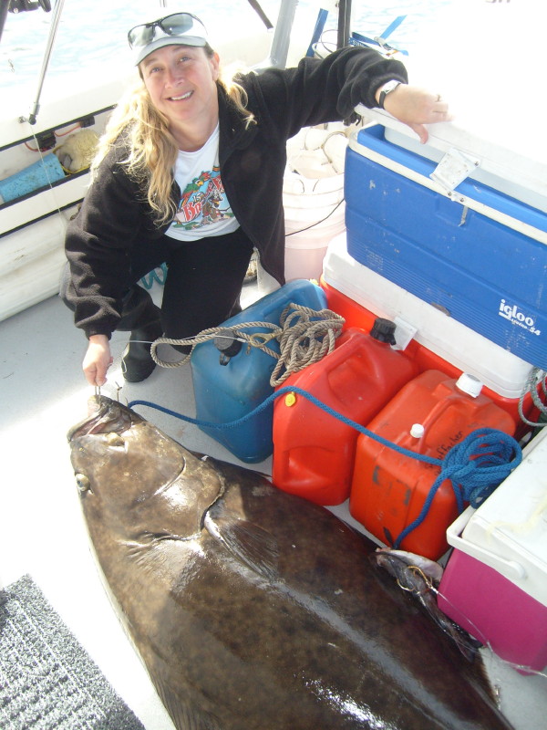 Shanna posing with the largest halibut she's ever caught.